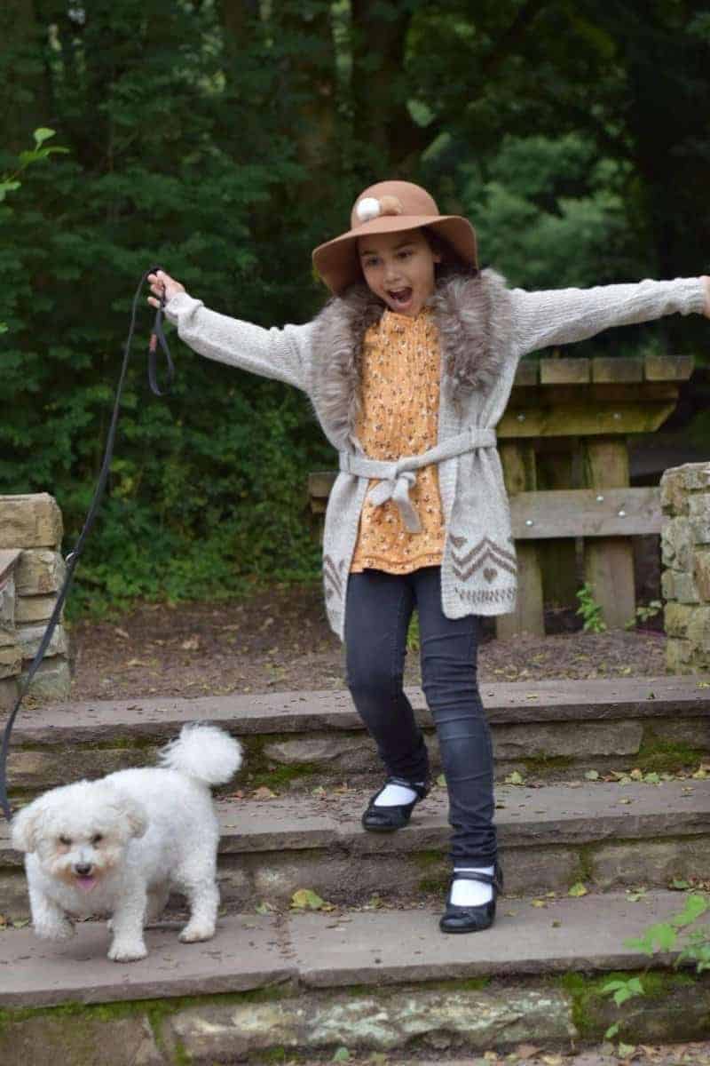 girl and bichon dog on stairs