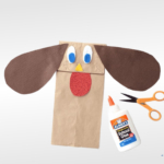 Paper bag dog craft and glue and scissors.