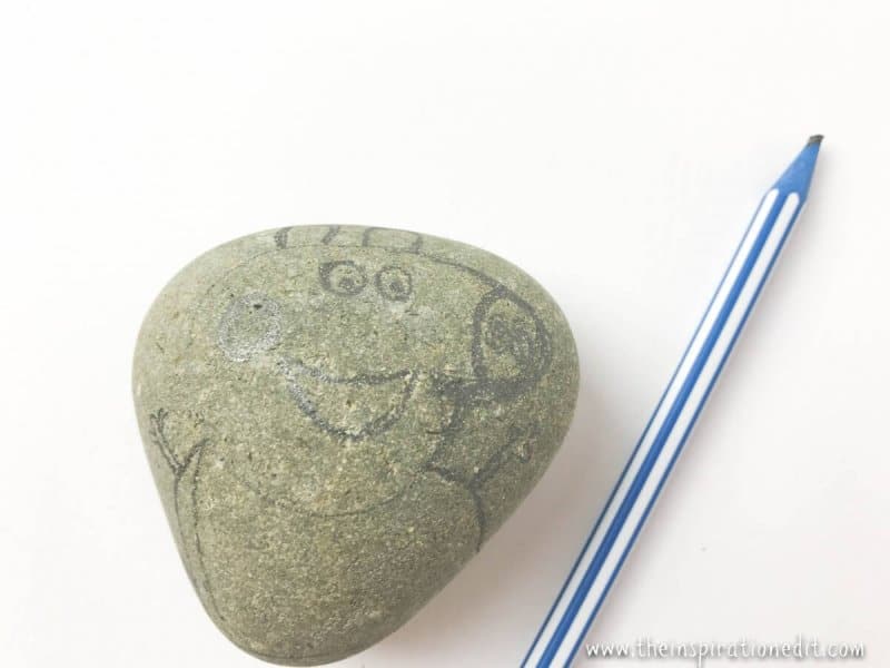 using the pencil to draw pepper pig onto the rock stone using the pencil to draw pepper pig onto the rock stone