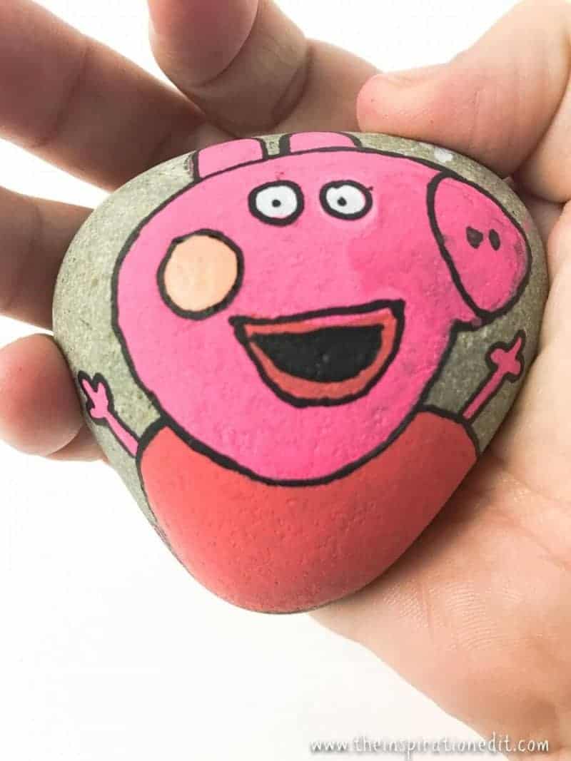 hand holding a Peppa Pig Rock painting hand holding a Peppa Pig Rock painting