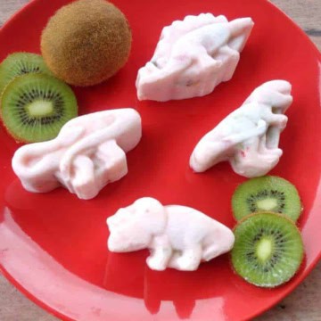 Strawberry kiwi frozen yogurt dinosaurs on a red plate.