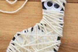 Halloween Art Projects the completed yarn mummy. A foot wrapped in white yarn with googly eyes.