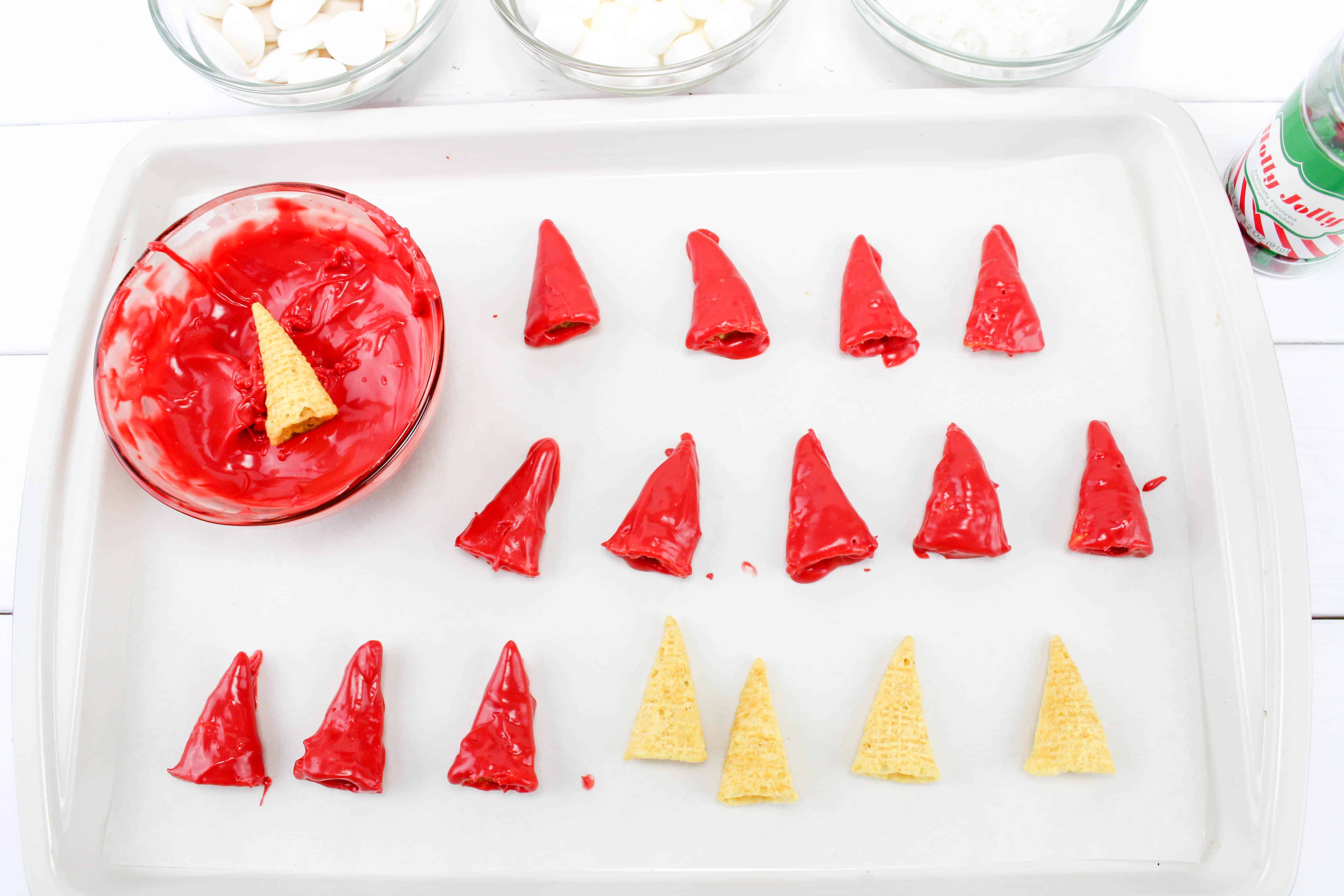 Dipping red bugles to red melted chocolate to make santa cap.