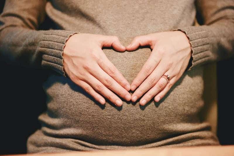 Hands on a pregnant belly.