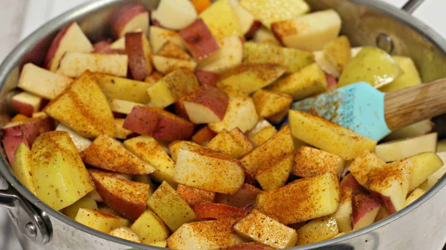 Potatoes with seasoning in a pot.