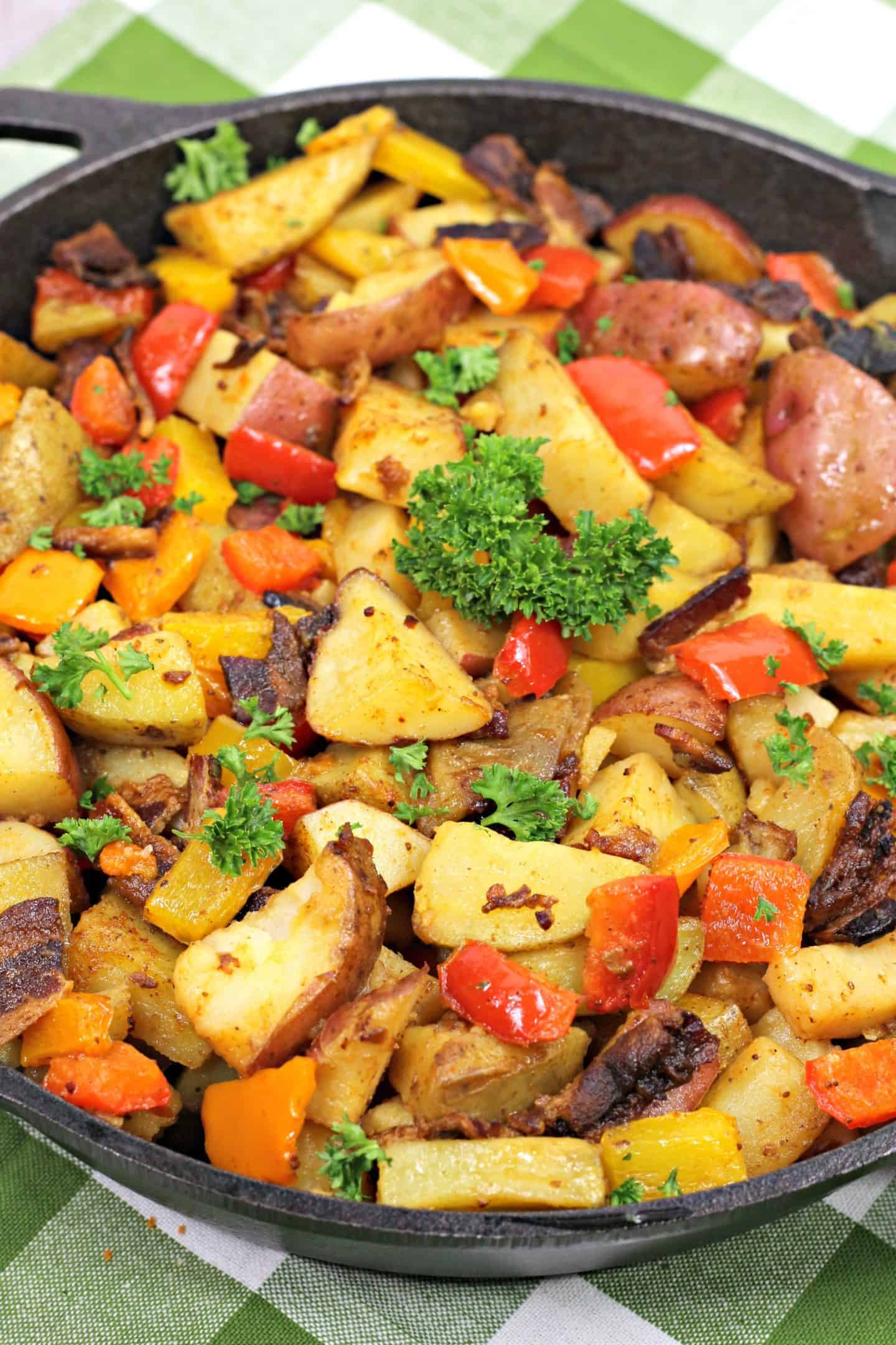 Close up of breakfast potatoes with bacon, peppers, and parsley.