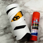 Toilet roll Mummy craft and a glue stick.