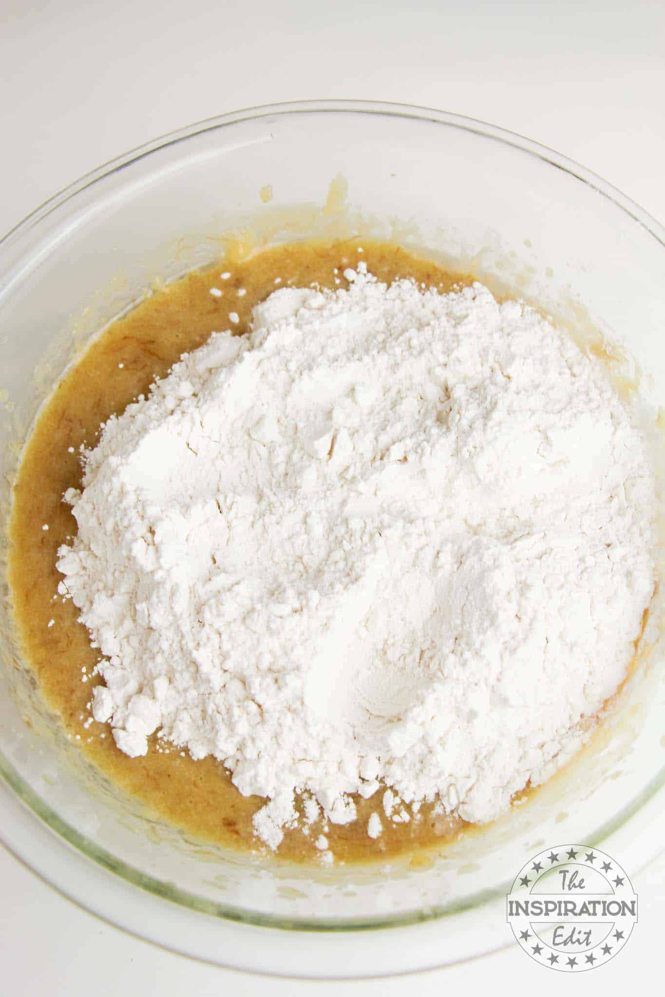 Flour on top of wet ingredients in a bowl.
