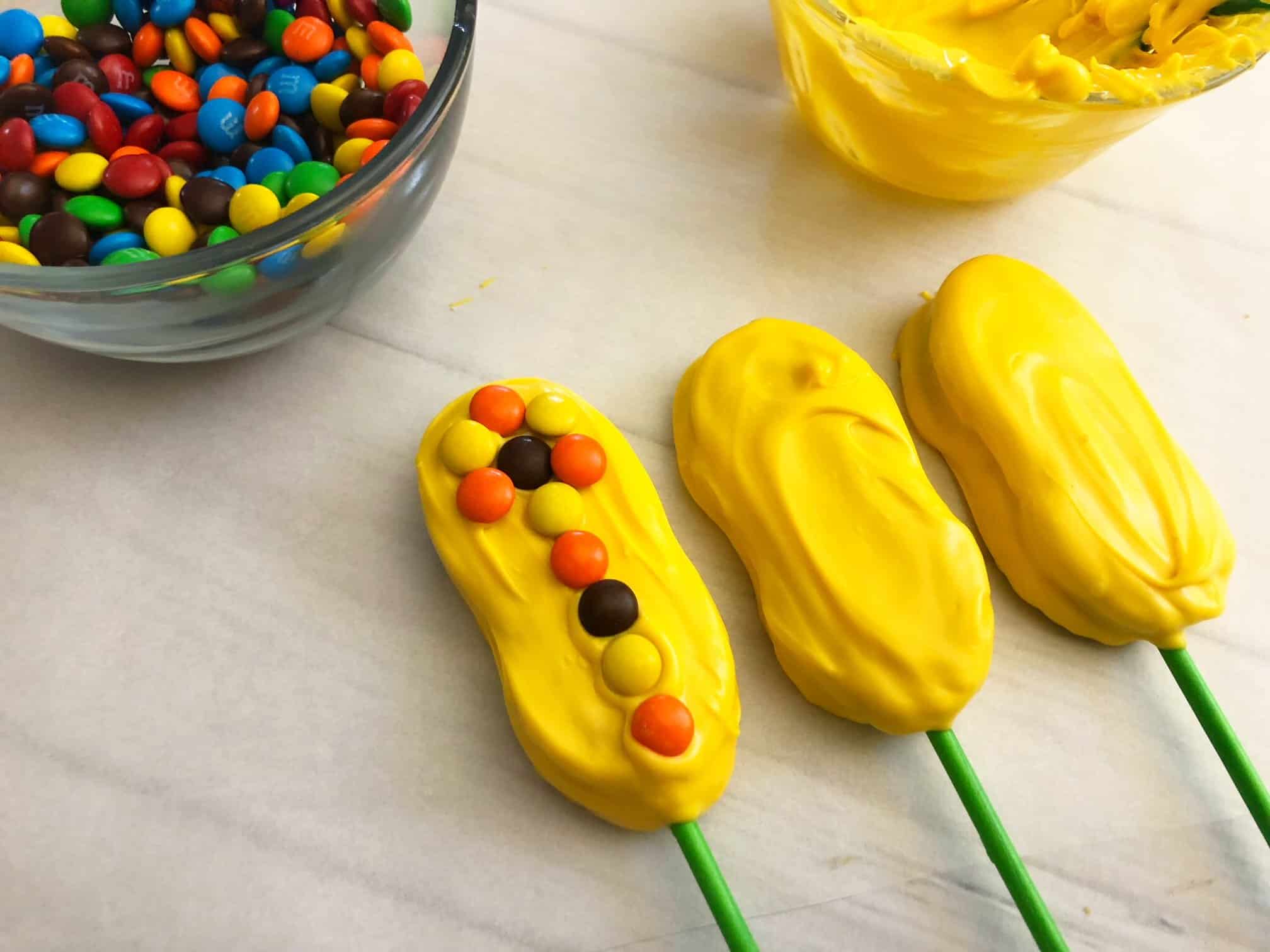 M&Ms on yellow chocolate covered Nutter Butters.