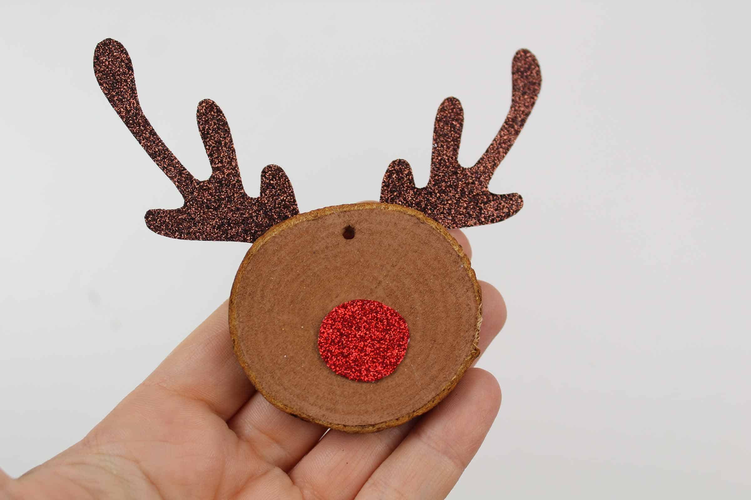 Sparkly antlers and red nose glued onto wooden slice.