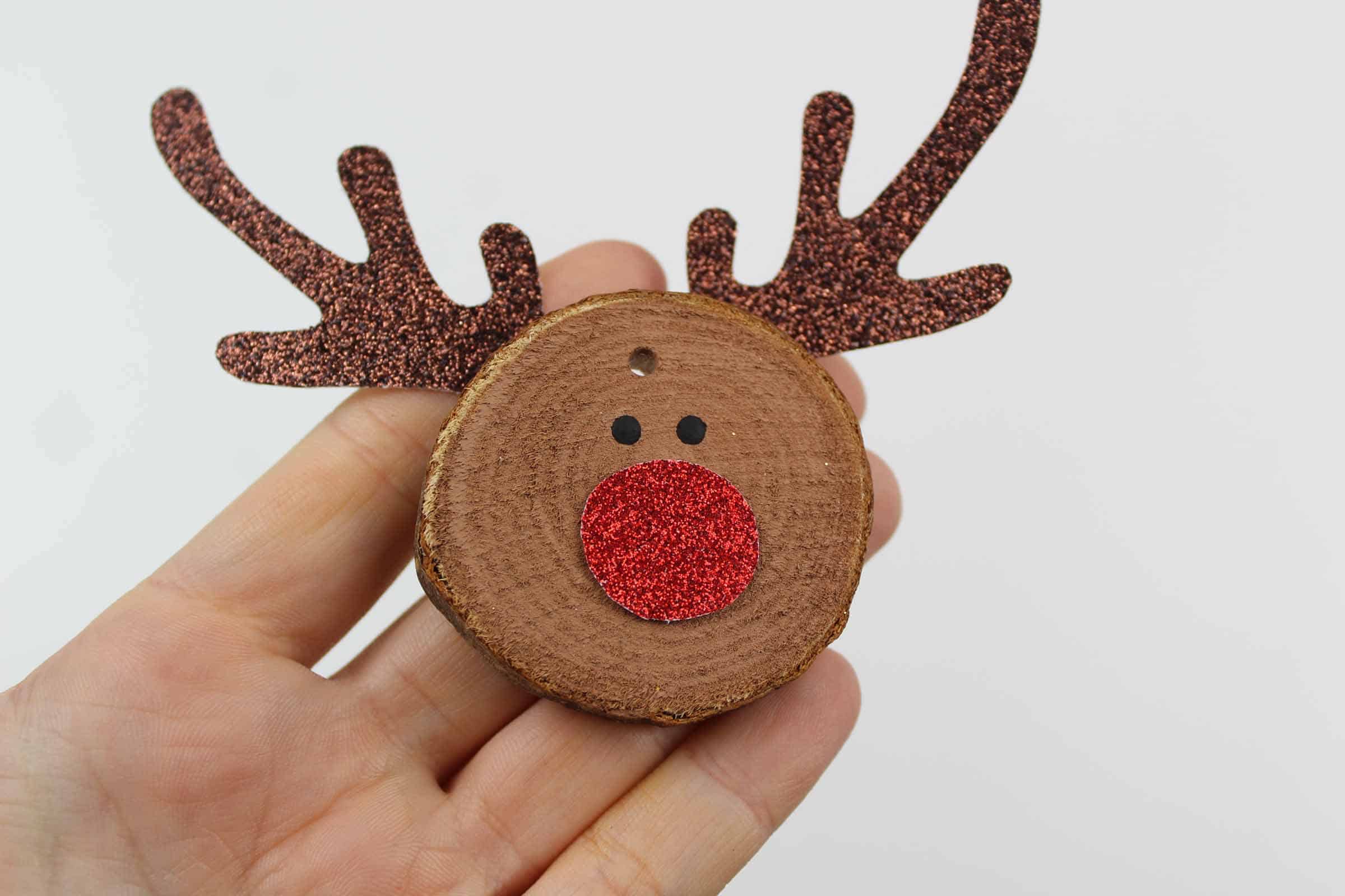 Hand holding rudolf craft ornament.