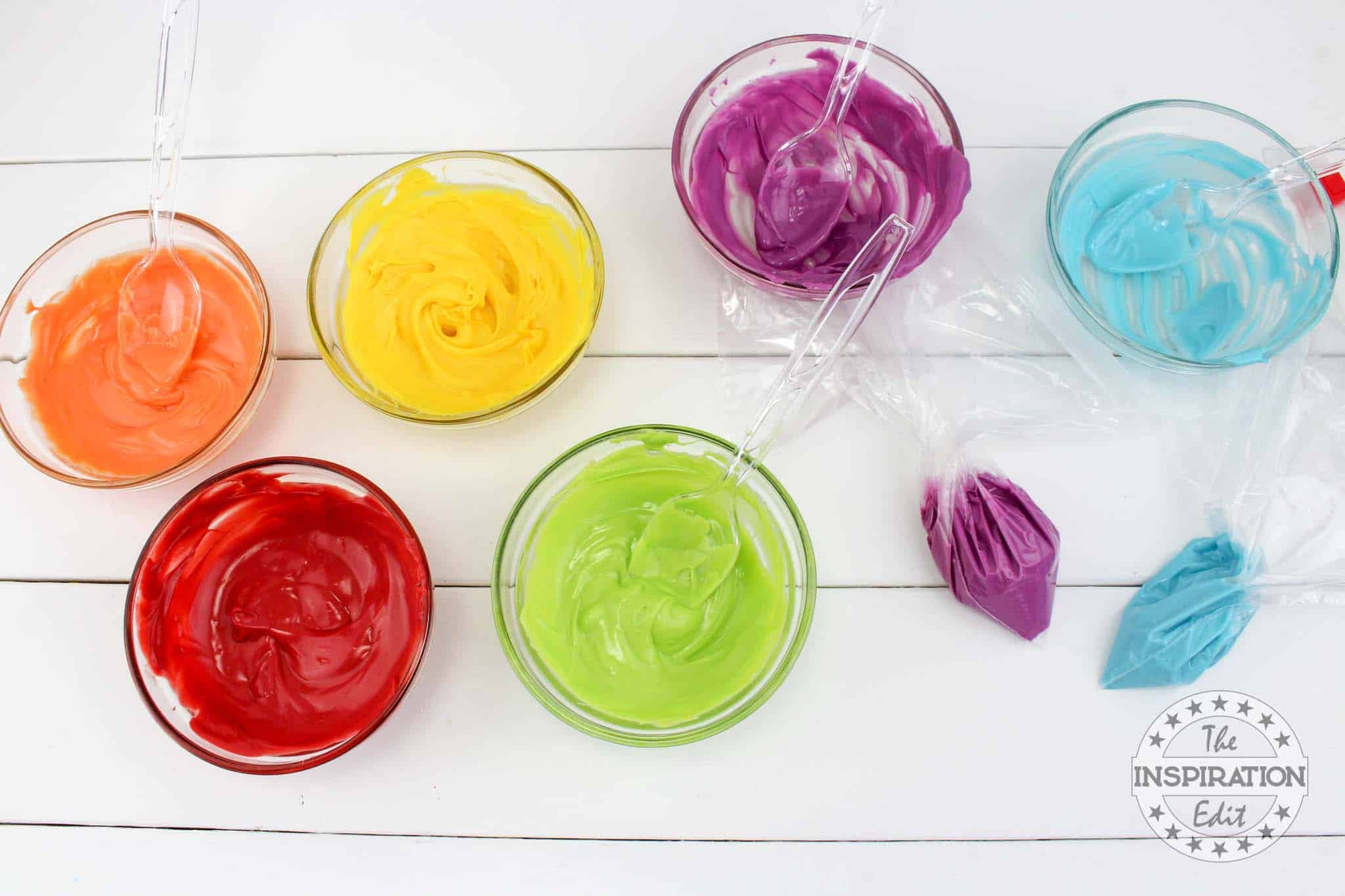 Different colors of melted chocolate in each bowl.