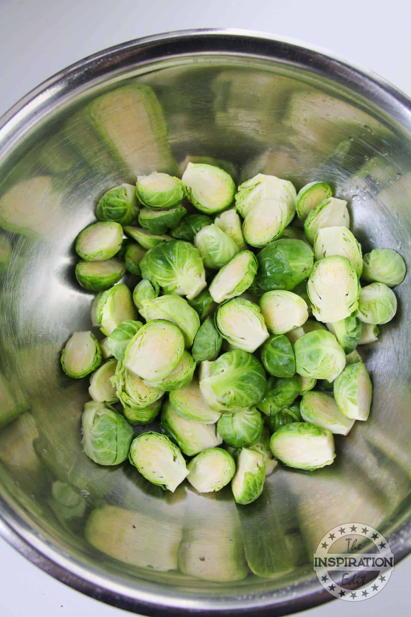 Raw brussel sprouts, cut in half, in a bowl