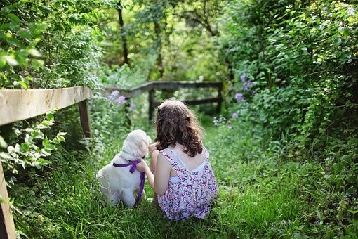 child and dog in garden.