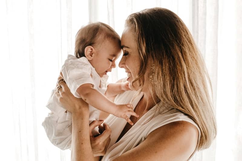 Smiling mother holding baby.