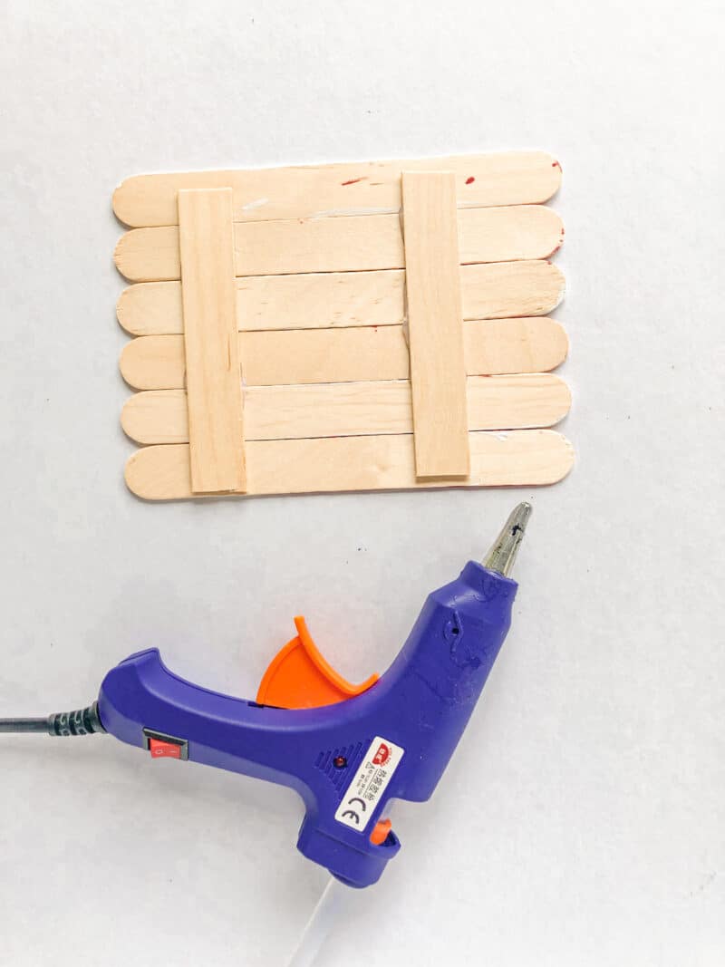 gluing two popsicle sticks on the back