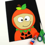 Boy pumpkin craft with a glue stick and a scissors.