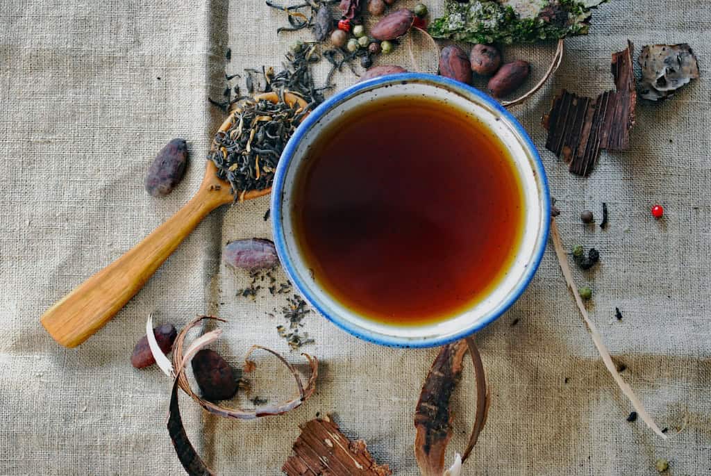 tea cup and spoonful herbs.