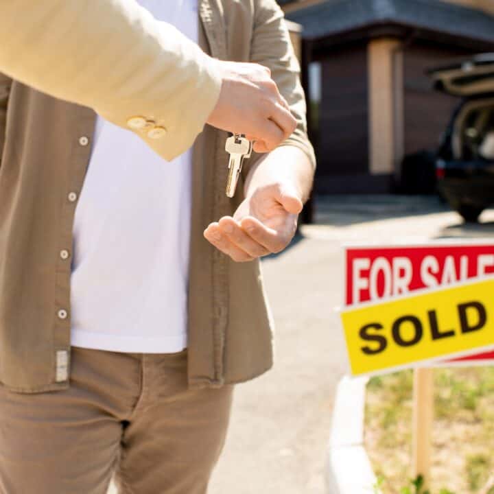 Stress-free way to sell your home | Someone handing over the keys to their new home.