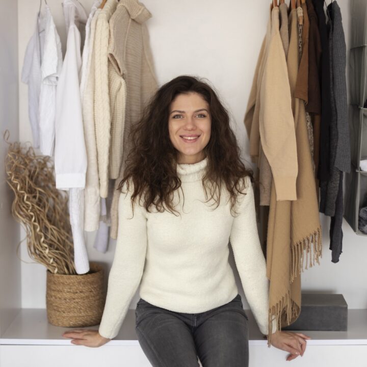 Why your closet feels like chaos | Woman sat in front of her wardrobe.
